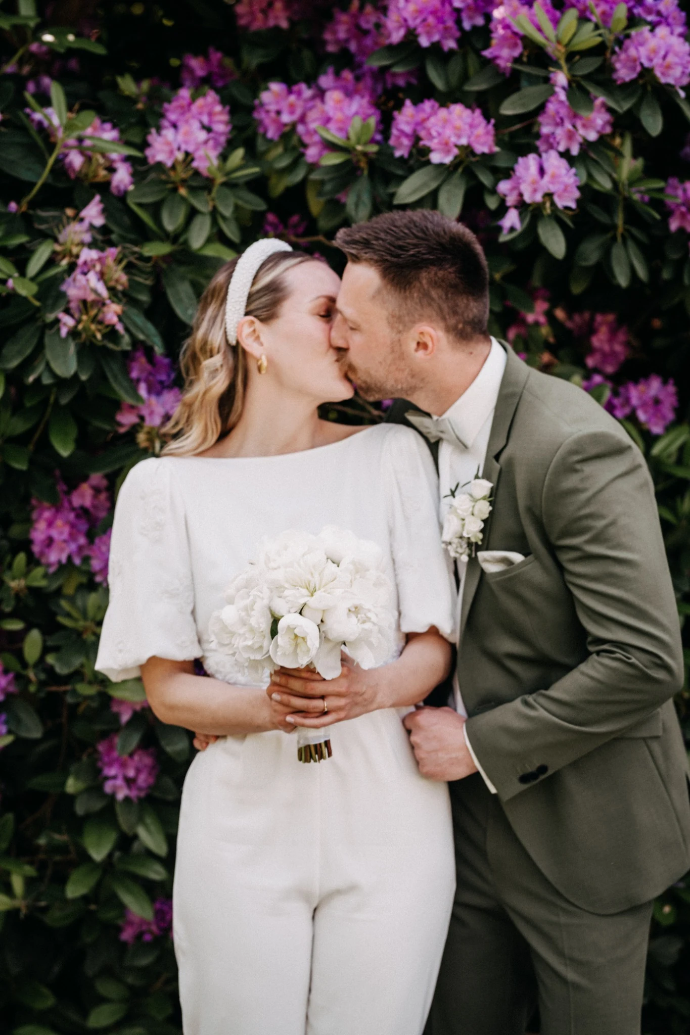 Birthe und Niklas küssen sich vor violetten Rhododendronblüten in Horneburg.