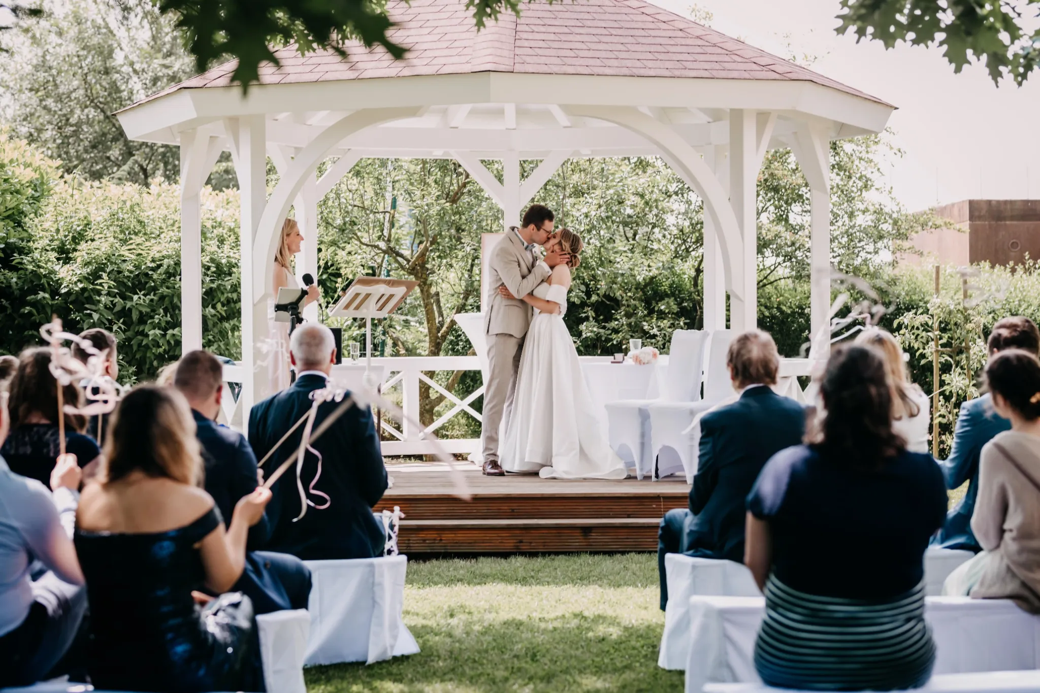 Hochzeitspaar bei einer freien Trauung unter einem Gartenpavillon.